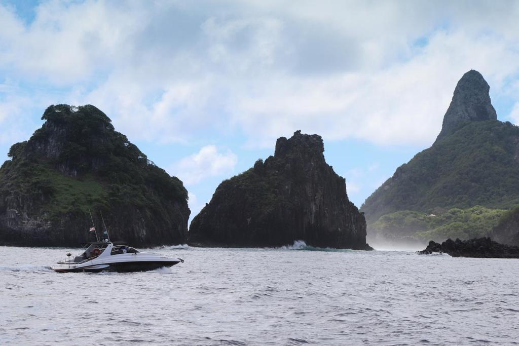 Lancha privativa navegando entre o Morro Dois Irmãos e o Morro do Pico em Fernando de Noronha
