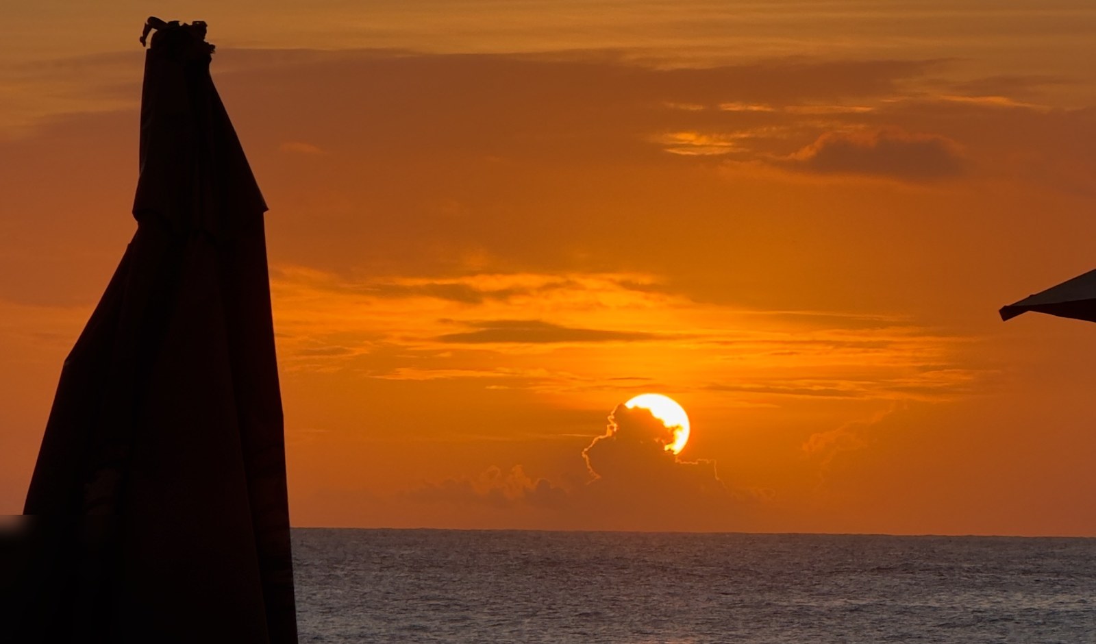 Pôr do sol no mar de dentro de Fernando de Noronha visto da praia
